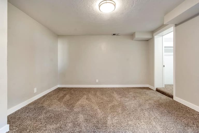 Second basement bedroom with carpet, doorway to hall, and clean neutral finish — Utah basement bedroom by CasaMás Construction