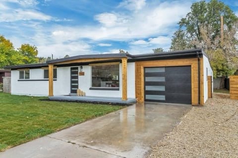 Mid-century home with enclosed carport converted to attached garage, wood-column entry, and modern garage door — Utah by CasaMás Construction