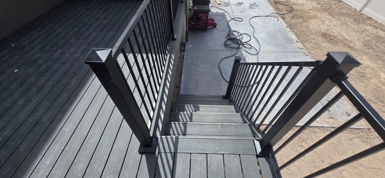 Detail of dark composite deck stair treads with black metal railing — Utah deck stair detail by CasaMás Construction