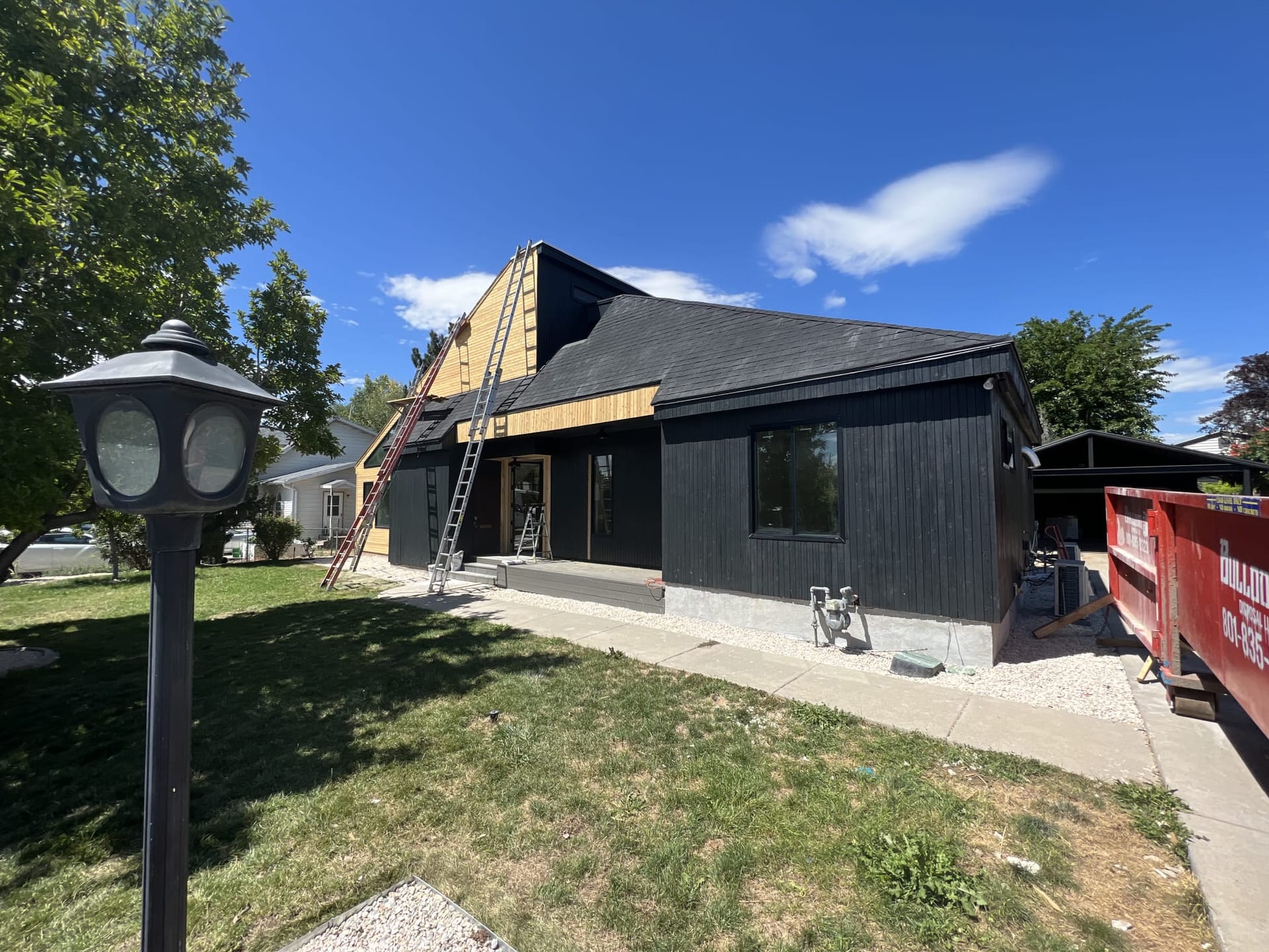 Modern dark home mid-construction with ladders and exposed framing on the new addition — Utah home addition in progress by CasaMás Construction