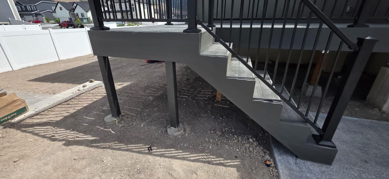 Same two-story deck build from a different angle showing the full connecting staircase — by CasaMás Construction